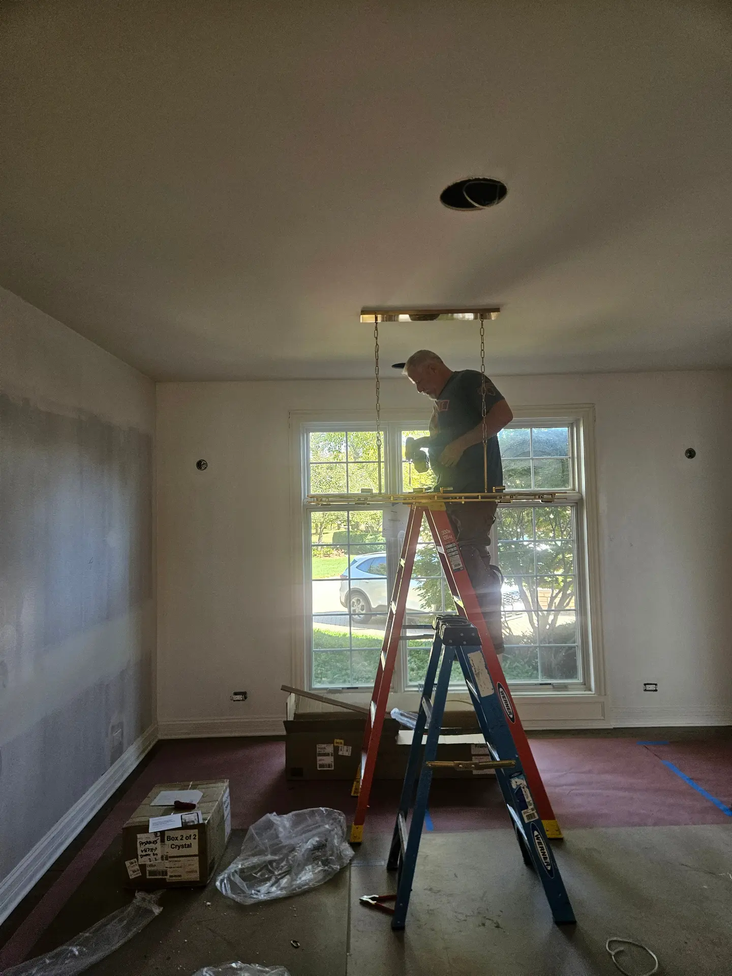 Electrician installing a brass light fixture